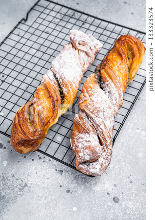 Danish pastry with Pistachios and chocolate, Puff pastry. grey background. top view Danish pastry with Pistachios and chocolate, Puff pastry. grey background. top view 133323574