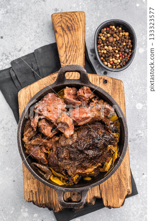 Red Wine Braised Beef Cheek meat with Creamy sauce in a skillet. grey background. top view 133323577