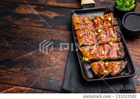 Japanese grilled eel with sweet soy sauce . wooden background. top view Japanese grilled eel with sweet soy sauce . wooden background. top view 133323582