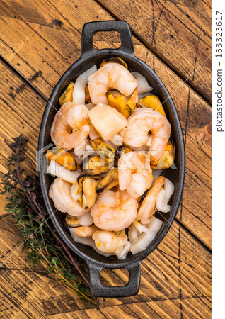 Ready for cooking fresh Raw Seafood Cocktail with Mussels, Clams, Prawns, Shrimps and squid in skillet. wooden background. top view Ready for cooking fresh Raw Seafood Cocktail with Mussels, Clams, Prawns, Shrimps and squid in skillet. wooden background. top view 133323617