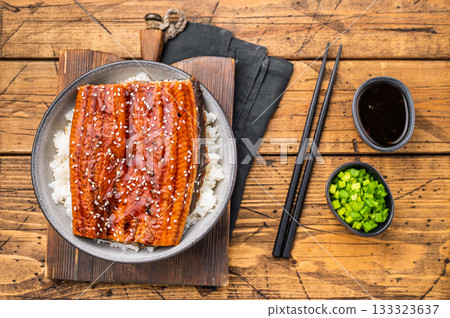 Unagi don or Japanese grilled eel rice in a bowl. wooden background. top view Unagi don or Japanese grilled eel rice in a bowl. wooden background. top view 133323637