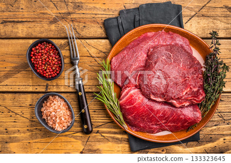 Traditional German beef cheeks, raw meat in plate. wooden background. top view 133323645