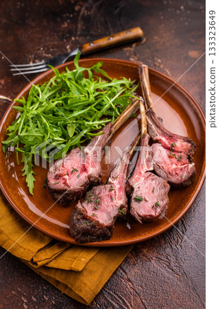 Roasted lamb chop cutlets, mutton meat steaks with salad. brown background. top view Roasted lamb chop cutlets, mutton meat steaks with salad. brown background. top view 133323649