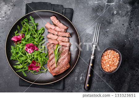 Grilled Top blade steak with salad, beef shoulder meat on a plate. black background. top view 133323651
