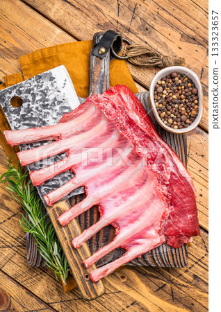 Butcher board with Raw lamb meat for chops steaks, fresh rack of mutton. wooden background. top view 133323657