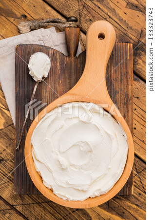 Italian Mascarpone cheese, cream cheese for tiramisu. wooden background. top view Italian Mascarpone cheese, cream cheese for tiramisu. wooden background. top view 133323743