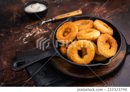 Crispy Fried onion rings, delicious snack in a pan. brown background. top view 133323749
