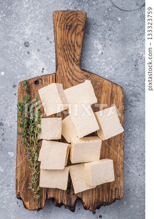 Organic Diced soy tofu cheese on wooden board. grey background. top view 133323759