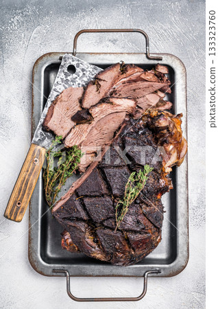 Roasted game meat of Venison, baked leg of roe deer on a tray with herbs. white background. top view Roasted game meat of Venison, baked leg of roe deer on a tray with herbs. white background. top view 133323760