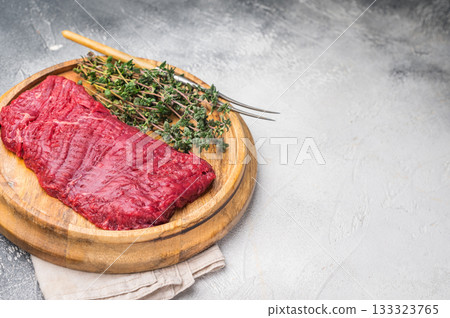 Flank steak, raw beef meat with herbs for frying. grey background. top view 133323765