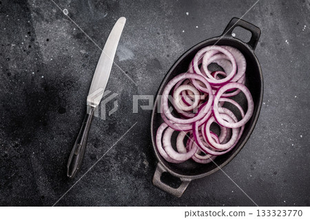 Fresh Raw onion rings in skillet. black background. top view 133323770