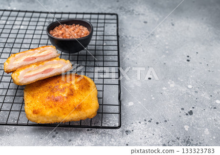 Fried Chicken cordon bleu cutlet with cheese and ham in breadcrumbs. grey background. top view 133323783