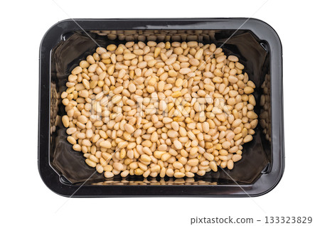 Fresh pine nuts packed in a black plastic container on a clean white background creating a minimal food image ideal for culinary and ingredient themes Fresh pine nuts packed in a black plastic container on a clean white background creating a minimal food image ideal for culinary and ingredient themes 133323829
