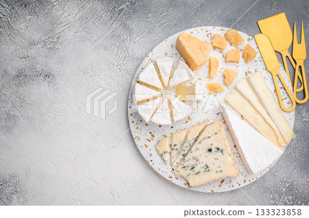 Variety of sliced Brie creamy Camembert aged Parmesan and Roquefort photographed on terrazzo with a subtle gray textured background. Variety of sliced Brie creamy Camembert aged Parmesan and Roquefort photographed on terrazzo with a subtle gray textured background. 133323858