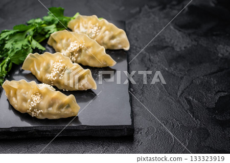 Steamed Japanese Gyoza Dumplings with meat and vegetables. black background. top view Steamed Japanese Gyoza Dumplings with meat and vegetables. black background. top view 133323919