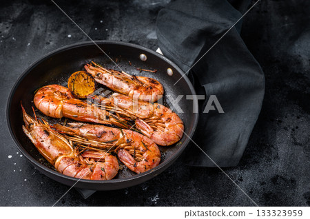 Pan fried red Argentine shrimps, Prawns Langostino Austral with herbs. black background. top view Pan fried red Argentine shrimps, Prawns Langostino Austral with herbs. black background. top view 133323959