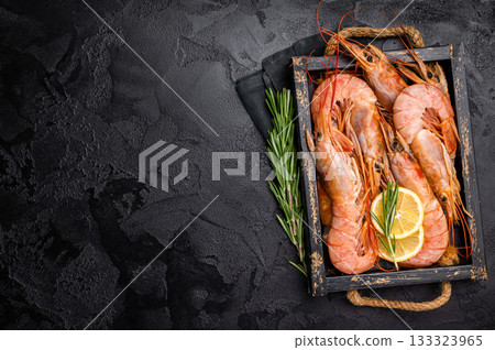 Uncooked raw Red shrimps, Prawns Langostino Austral in wooden tray. black background. top view Uncooked raw Red shrimps, Prawns Langostino Austral in wooden tray. black background. top view 133323965