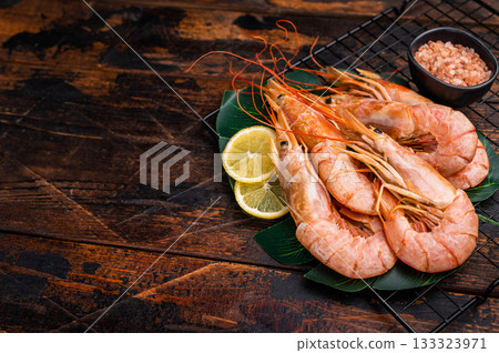 Raw Red Langostino Austral shrimps on rack with herbs. wooden background. top view Raw Red Langostino Austral shrimps on rack with herbs. wooden background. top view 133323971
