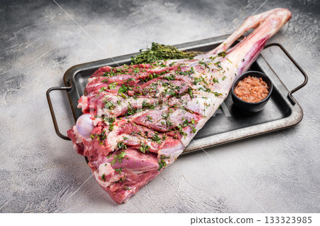Marinated with herbs and olive oil raw goat leg. white background. top view 133323985