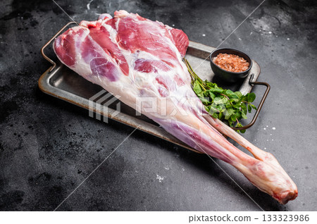 Uncooked whole mutton leg, raw organic lamb meat. black background. top view 133323986