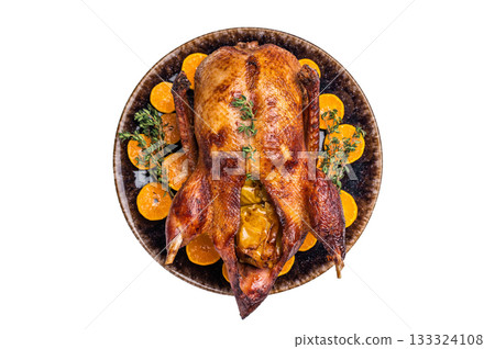 Roast goose with apples and oranges on plate with herbs isolated on white background. top view 133324108