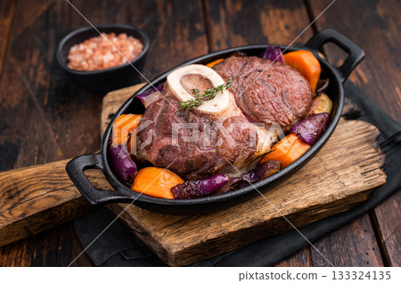 Hearty ossobuco slow cooked to perfection, showcasing succulent osso buco shank meat and aromatic herbs in a comforting stew. wooden background. top view Hearty ossobuco slow cooked to perfection, showcasing succulent osso buco shank meat and aromatic herbs in a comforting stew. wooden background. top view 133324135