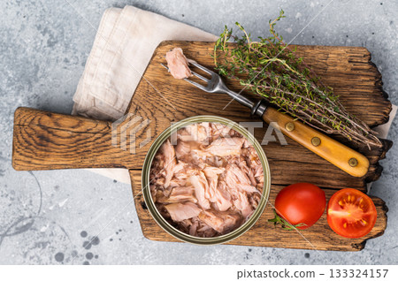 Delicious canned tuna in olive oil, ideal for salads, sandwiches, or as a savory snack on the go. grey background. top view Delicious canned tuna in olive oil, ideal for salads, sandwiches, or as a savory snack on the go. grey background. top view 133324157