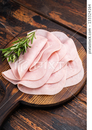 Close up of savory sliced ham showcasing its rich color and texture, a must-have for any deli lover. wooden background. top view Close up of savory sliced ham showcasing its rich color and texture, a must-have for any deli lover. wooden background. top view 133324164