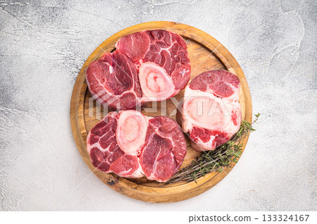 Beautifully marbled raw veal ossobuco, perfect cross cut shank meat for traditional Italian recipes and savory family dinners. white background. top view Beautifully marbled raw veal ossobuco, perfect cross cut shank meat for traditional Italian recipes and savory family dinners. white background. top view 133324167