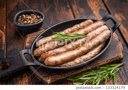 Delicious grilled sausage served with fresh herbs, a mouthwatering addition to any picnic or backyard party. wooden background. top view Delicious grilled sausage served with fresh herbs, a mouthwatering addition to any picnic or backyard party. wooden background. top view 133324179