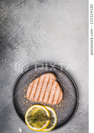 Deliciously charred grilled tuna steak, served with fresh herbs, a healthy and flavorful choice for any meal. white background. top view 133324180