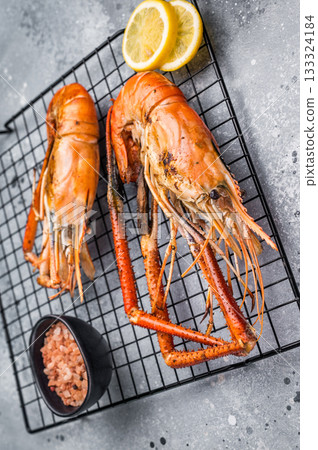 Close up of beautifully grilled rosenbergii prawn, showcasing its smoky glaze and appetizing texture. grey background. top view 133324184