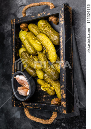 Sweet and tangy pickled cucumbers, ideal for enhancing burgers and wraps with a burst of flavor. black background. top view Sweet and tangy pickled cucumbers, ideal for enhancing burgers and wraps with a burst of flavor. black background. top view 133324186