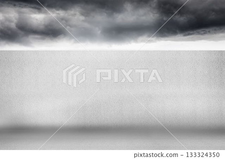 Flat design showing empty concrete floor and light-gray textured wall under dark storm clouds Flat design showing empty concrete floor and light-gray textured wall under dark storm clouds 133324350