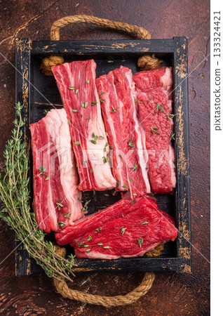 Top view of fresh, marbled short ribs ready for cooking. Dark, moody, high-end food photography with ample copy space. Top view of fresh, marbled short ribs ready for cooking. Dark, moody, high-end food photography with ample copy space. 133324421