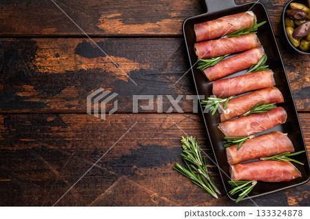Appetizing plate of thinly sliced cured Italian ham (Prosciutto Crudo) garnished with rosemary sprigs. Appetizing plate of thinly sliced cured Italian ham (Prosciutto Crudo) garnished with rosemary sprigs. 133324878