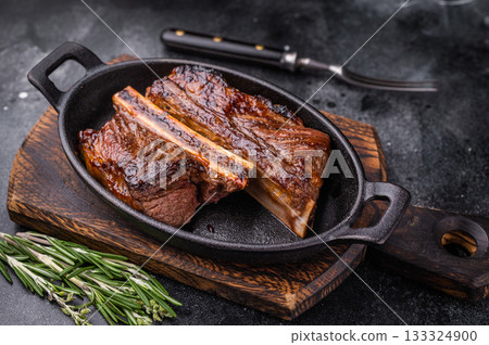 Gourmet grilled short ribs on a dark background with plenty of negative space for custom text or design. 133324900