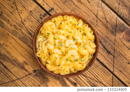 Creamy mac and cheese in a rustic bowl on a wooden table, garnished with fresh thyme, Creamy mac and cheese in a rustic bowl on a wooden table, garnished with fresh thyme, 133324905