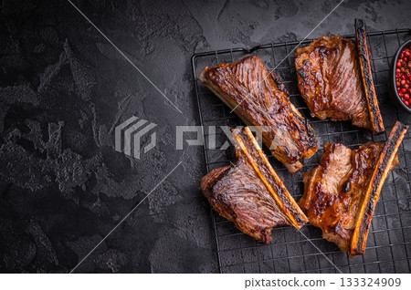 High contrast BBQ ribs shot with pink peppercorns. Dark and moody food photography for web banners. 133324909
