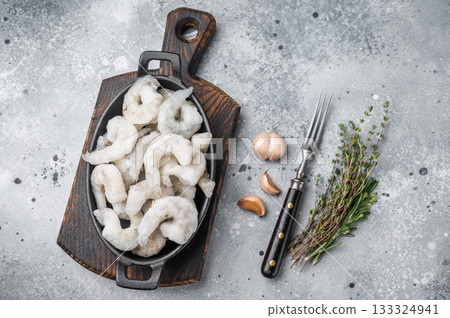 Top view of icy prawns shrimps and herbs on a grey textured surface. Healthy protein food preparation with ample space for text. Top view of icy prawns shrimps and herbs on a grey textured surface. Healthy protein food preparation with ample space for text. 133324941