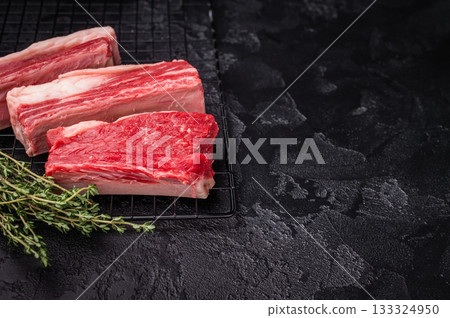 High-quality meat preparation. Raw beef cut with herbs and spices on a black textured background. Copy space provided. High-quality meat preparation. Raw beef cut with herbs and spices on a black textured background. Copy space provided. 133324950