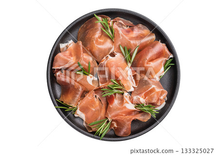 Delicious dry cured Jamon pork meat served with fresh herbs. Clean overhead view, perfect for a culinary theme. Delicious dry cured Jamon pork meat served with fresh herbs. Clean overhead view, perfect for a culinary theme. 133325027