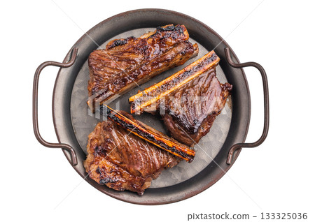 Grilled beef short ribs: Succulent, caramelized short ribs served on a rustic metal tray against a clean white background. Grilled beef short ribs: Succulent, caramelized short ribs served on a rustic metal tray against a clean white background. 133325036