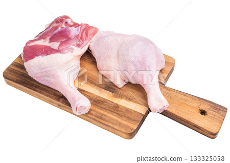 Raw duck leg presented against a clean white surface, perfect for culinary stock imagery. 133325058