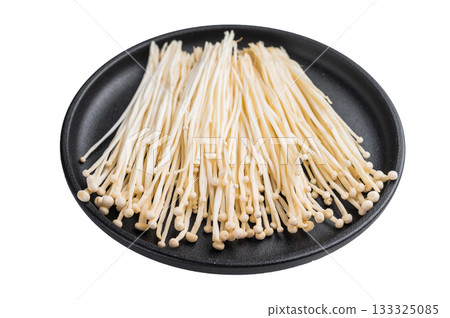 Top view of raw Enokitake mushrooms on a black dish. Healthy, gourmet Asian ingredient ready for serving or plating. Top view of raw Enokitake mushrooms on a black dish. Healthy, gourmet Asian ingredient ready for serving or plating. 133325085