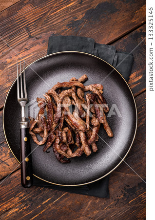 BBQ Fried beef tender strips, sliced steak in a plate. wooden background. top view 133325146