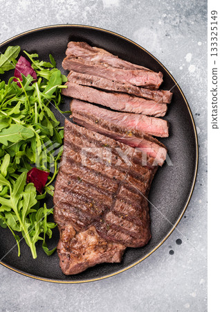 Barbecue dry aged wagyu entrecot steak on plate with salad. grey background. top view Barbecue dry aged wagyu entrecot steak on plate with salad. grey background. top view 133325149