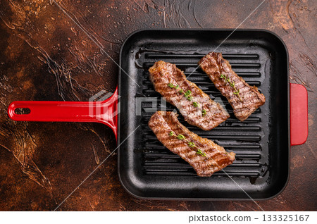 Grilled Tri tip steaks, marbled beef meat on pan with herbs. brown background. top view Grilled Tri tip steaks, marbled beef meat on pan with herbs. brown background. top view 133325167