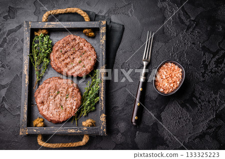 Grilled hamburger mince meat patties with herbs. black background. top view Grilled hamburger mince meat patties with herbs. black background. top view 133325223