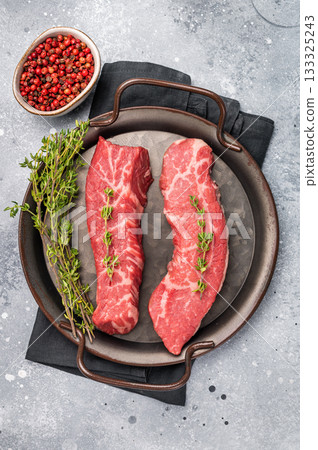Raw Tri Tip Steak from Black Angus beef meat in stell tray. grey background. top view 133325243